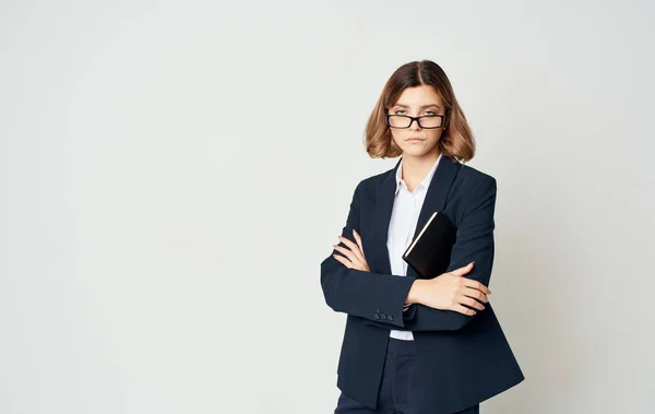 Donna d'affari in giacca blu e camicia bianca con gli occhiali sul viso e un libro in mano — Foto Stock