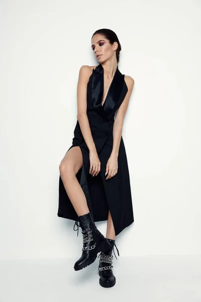 Siyah elbiseli güzel bir kadın. Moda botları. Modern tarz hafif arka plan. — Stok fotoğraf