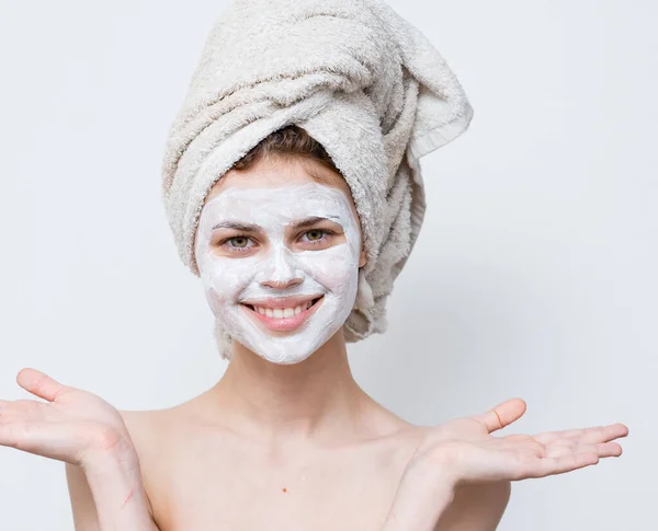 Kobieta w białej masce przeciwko czarnym kropkom na twarzy i ręczniku na głowie — Zdjęcie stockowe