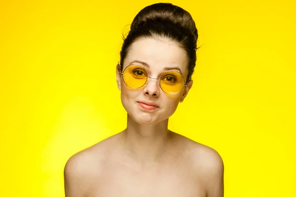 Bruneta s holými rameny žluté brýle emoce oříznuté pohled studio — Stock fotografie