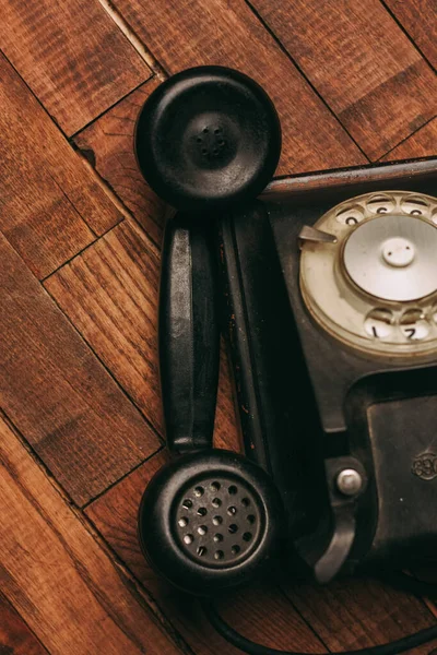 Retro telefone preto em um clássico piso de madeira — Fotografia de Stock
