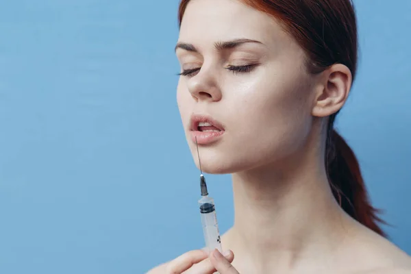 Mujeres dan inyecciones en la cara en una jeringa de fondo azul cambio en la apariencia de la vacuna — Foto de Stock