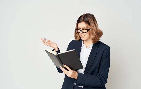 Donna d'affari in giacca blu e camicia bianca con gli occhiali sul viso e un libro in mano — Foto Stock