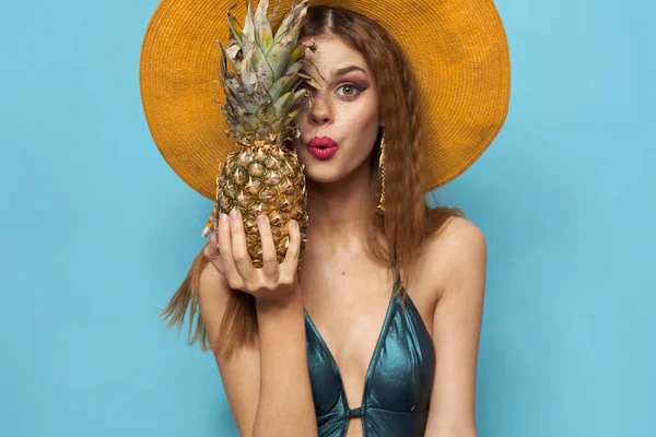 Frau mit Strandhut Ananas hält Badeanzug exotische Früchte blauen Hintergrund Urlaub — Stockfoto