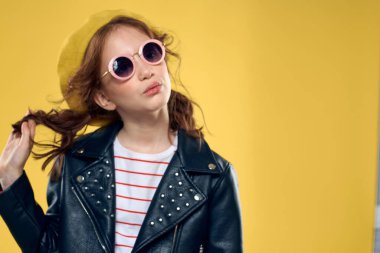 Sarı şapkalı bir kız. Koyu gözlükler, şık kıyafetler. Stüdyo hayatı, çocukluk.