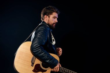 Elinde gitar olan bir adam deri ceketli müzik performansı rock yıldızı modern tarz koyu arkaplan