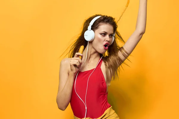 Woman in headphones listens to music emotions lifestyle fun yellow background — Stock Photo, Image