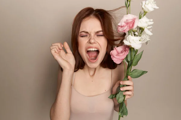 Lycklig kvinna med en bukett av ljusa blommor på en beige bakgrund nakna axlar modell rött hår vackert ansikte — Stockfoto