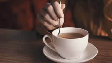 Çay masasında beyaz bardakta sıcak bir içecek.