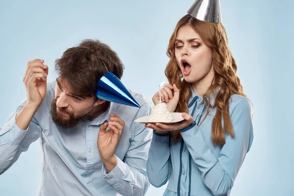 Homem alegre e mulher com bolo em uma placa de festa corporativa fundo azul — Fotografia de Stock