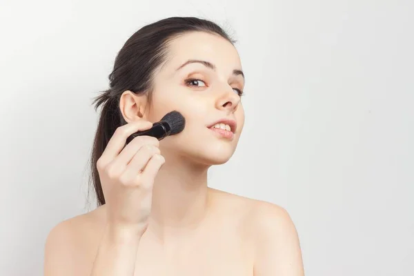Frau mit nackten Schultern als Gesichtsmaskenpinsel für die Hautpflege — Stockfoto