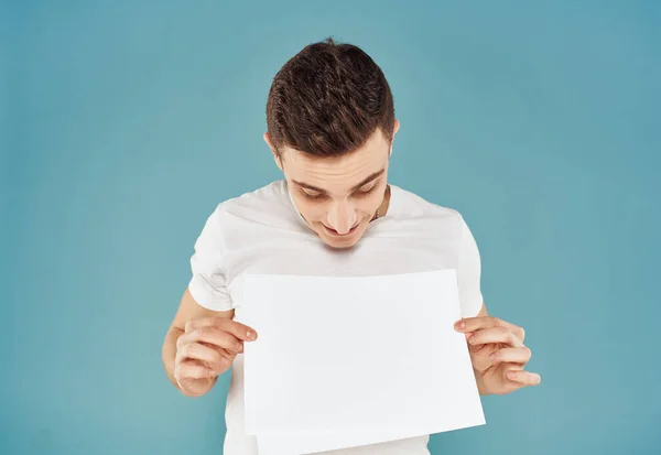 Annonceur masculin avec une feuille de papier blanche sur un fond bleu maquette Flyer — Photo