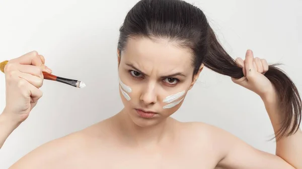 Mulher com ombros nus está na mão aplicando cosméticos cuidados com a pele — Fotografia de Stock