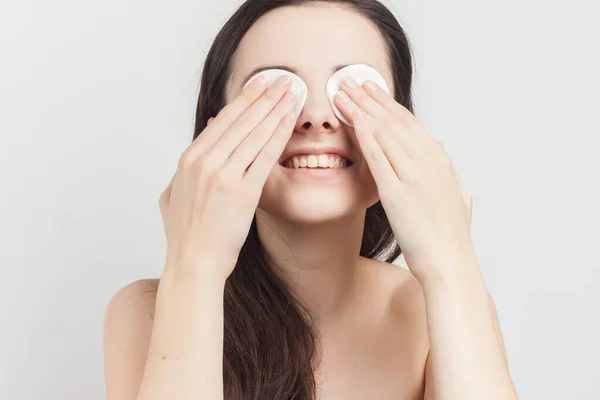 Mujer emocional con hombros desnudos esponjas cerca de cosméticos de la cara cuidado — Foto de Stock