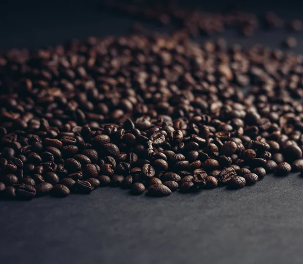 Aromatické kávová zrna na tmavém pozadí detailní záběr zblízka — Stock fotografie