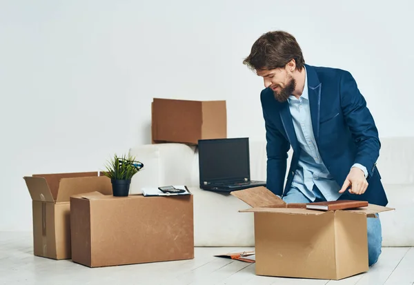 Um homem senta caixas com coisas desempacotando um novo emprego profissional — Fotografia de Stock