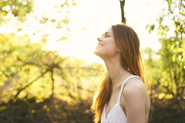 Happy red-haired woman on nature in the forest near green trees Summer sun — Stock Photo, Image