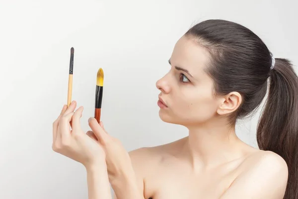 Frau trägt Make-up-Pinsel auf Gesichtshaut auf — Stockfoto