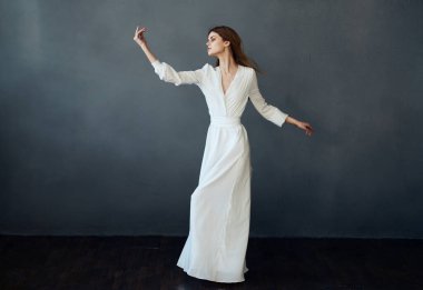 Beyaz elbiseli çekici kadın dans performansı cazibesi gri arka plan modeli