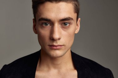 Yakışıklı genç adam, şık saç stili siyah ceketli, yakın plan. 