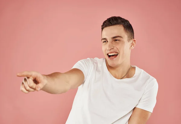 Allegro uomo gesti con le emozioni della mano bianco t-shirt rosa sfondo — Foto Stock