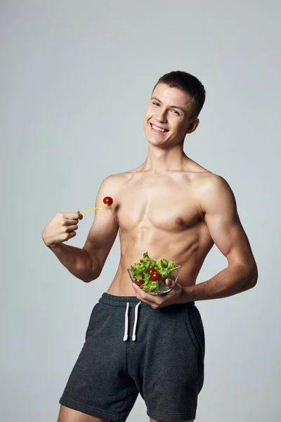 Veselý chlap s napumpované svalové svaly talíř salát dieta jídlo izolované pozadí — Stock fotografie