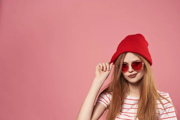 Lunettes de soleil femme à la mode et chapeau rouge studio rose fond mode — Photo