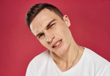 Beyaz tişörtlü duygusal adam stüdyo tatminsizliği kırmızı arka plan