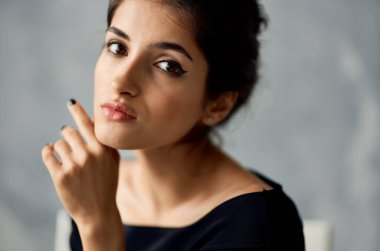 Gri arka plan portresi üzerinde gece elbisesi ve küpeleri olan romantik bir bayan.