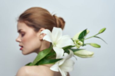 Gri arkaplan portresi üzerinde bir buket beyaz çiçekli bayan yakın çekimde kesilmiş.