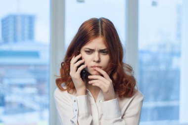 Ofisteki kadın yönetici telefon teknolojisi hakkında konuşuyor.