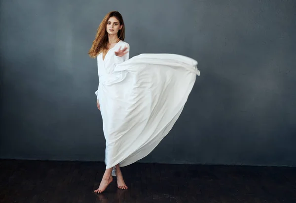 Μια ρομαντική γυναίκα με λευκό φόρεμα σε πλήρη ανάπτυξη χορεύει σε γκρι φόντο — Φωτογραφία Αρχείου