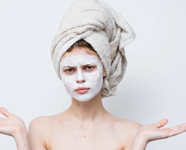 Mulher com uma máscara branca contra pontos pretos no rosto e uma toalha na cabeça — Fotografia de Stock