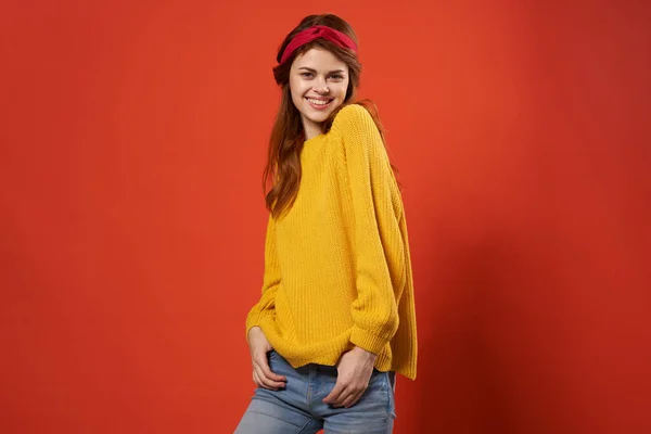 매력적 인 여자노란 스웨터, 유행하는 옷입는 거리의 빨간 배경 — 스톡 사진