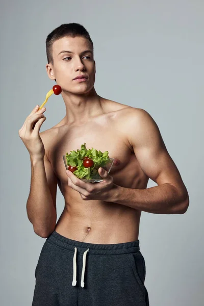 Atletický muž s svalnatým tělem talíř světle zelené jídlo energie — Stock fotografie
