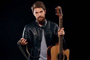 Elinde gitar olan bir adam deri ceketli müzik performansı rock yıldızı modern tarz koyu arkaplan