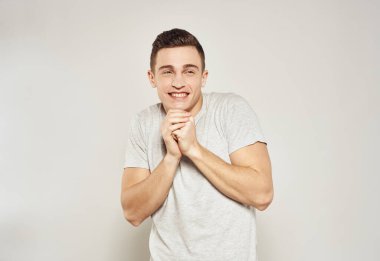 Beyaz tişörtlü bir adam elleri ve duyguları ile hareket eder stüdyo ışığı arka planı