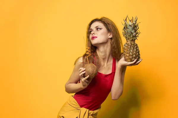 Ładna kobieta z ananasem w dłoniach kosmetyki egzotyczne owoce żółty tło zabawa — Zdjęcie stockowe
