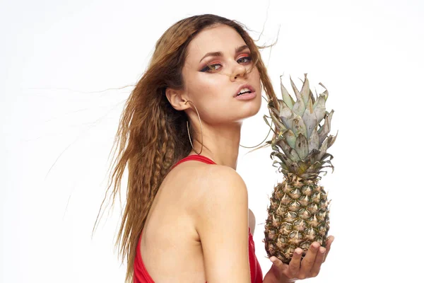 Mulher com abacaxi em mãos ondulado cabelo vermelho t-shirt frutas verão férias luz fundo — Fotografia de Stock