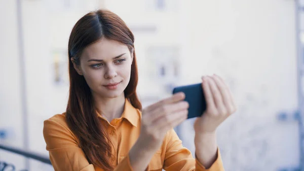 Mujer bonita con teléfono en las manos al aire libre fotografía tecnología — Foto de Stock