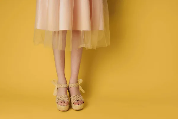 Женщина в обуви платье ноги привлекательный вид желтый фон моды — стоковое фото