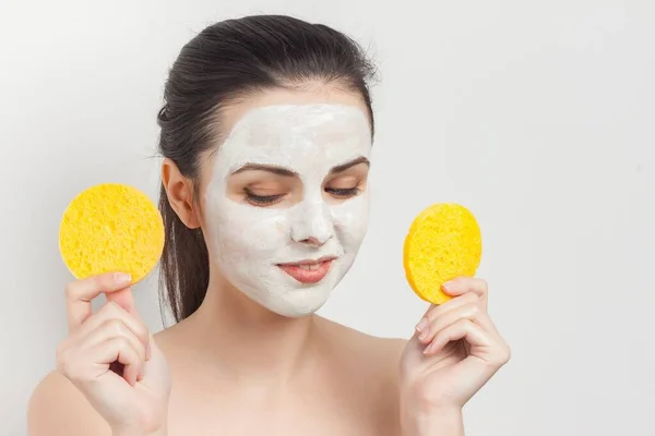 Brunette menyeka masker wajah dengan spons dipangkas tampilan — Stok Foto