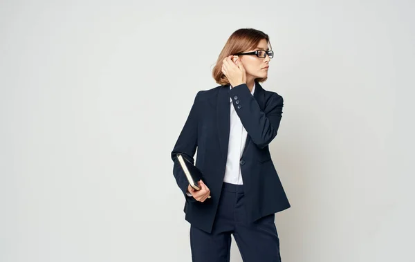 Mujer de negocios con chaqueta azul y camisa blanca con gafas en la cara y un libro en las manos — Foto de Stock
