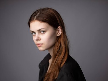 Siyah ceketli kadın portresi. Kızıl saçlı, gri arka plan kırpık manzaralı.