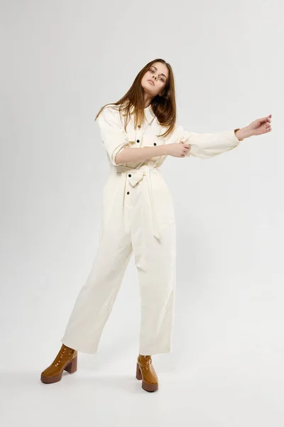 Красива жінка жестикулює руками в білому комбінезоні моди — стокове фото