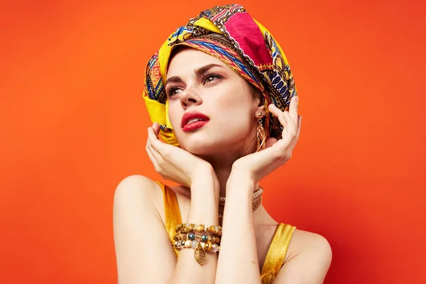 Kvinna med flerfärgad turban på huvudet halv kosmetika dekoration isolerad bakgrund — Stockfoto