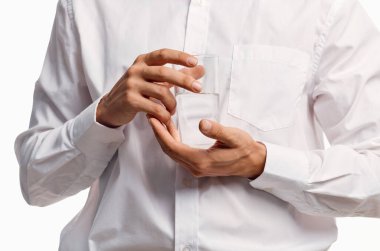 Beyaz gömlekli bir beyefendi arka planda bir bardak su tutuyor.