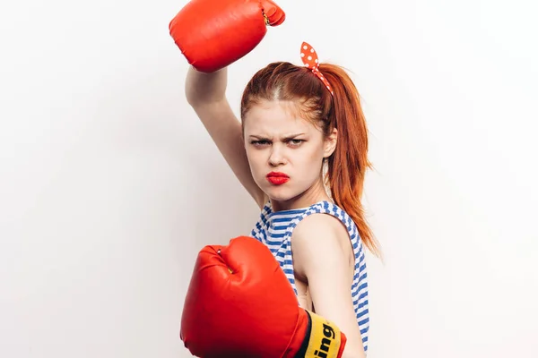 Femme dans un t-shirt rayé et dans des gants rouges sont engagés dans l'agression de boxe maquillage bouche grande ouverte — Photo