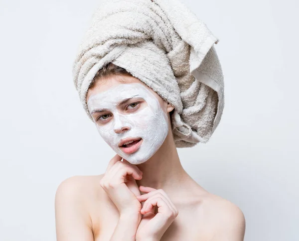 Femme avec de la crème sur son visage serviette sur sa tête soin de la peau — Photo