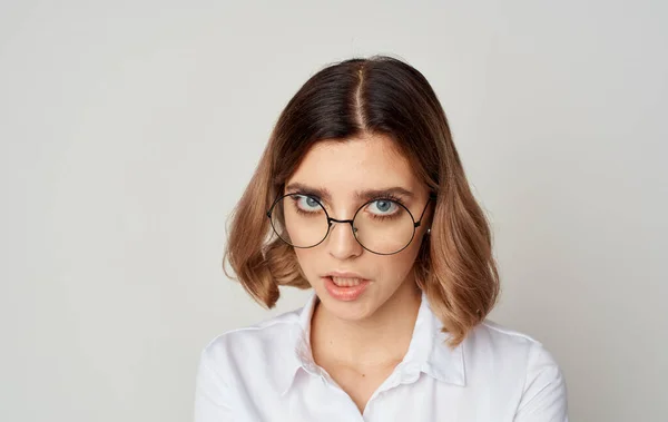 Vacker kvinna bär glasögon kort hår vit skjorta och beige bakgrund — Stockfoto